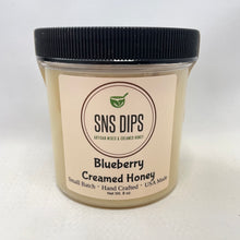 Load image into Gallery viewer, A jar of Sweet and Natural Blueberry Creamed Honey by SnS Dips, with a label indicating it's a small batch, hand-crafted product made in the USA.
